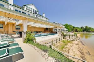 a building with a swimming pool next to a river at Beachfront Onekama Vacation Rental with Balcony! in Onekama