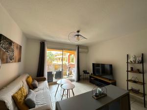 a living room with a couch and a table at Malibu Village T2 in Canet-en-Roussillon