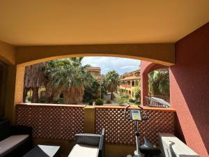 a balcony with a view of a building and palm trees at Malibu Village T2 in Canet-en-Roussillon
