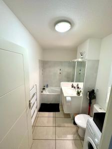 a bathroom with a tub and a sink and a toilet at Malibu Village T2 in Canet-en-Roussillon +12 photos
