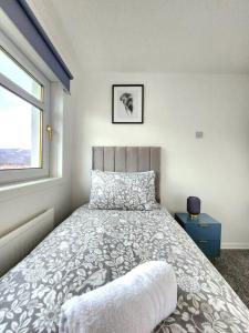un letto in una camera da letto con finestra e un letto sidx sidx. di Quirky Home, Quiet Neighbourhood a Newton Mearns