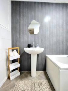 bagno con lavandino bianco e vasca di Quirky Home, Quiet Neighbourhood a Newton Mearns