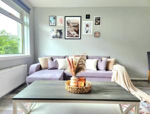 a living room with a purple couch and a table at Quirky Home, Quiet Neighbourhood in Newton Mearns