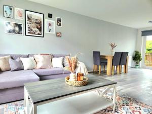 a living room with a purple couch and a table at Quirky Home, Quiet Neighbourhood in Newton Mearns