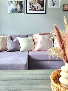a living room with a purple couch with pillows at Quirky Home, Quiet Neighbourhood in Newton Mearns