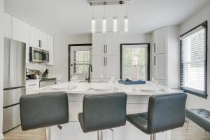 a kitchen with a large white island with chairs at Modern Raleigh Vacation Rental about 3 Mi to Downtown! in Raleigh