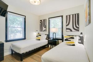 two beds in a room with two windows at Modern Raleigh Vacation Rental about 3 Mi to Downtown! in Raleigh