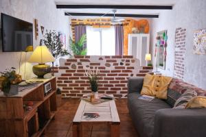 - un salon avec un canapé et un mur en briques dans l'établissement Cuarto Teide Apartamento Santo Domingo, à La Guancha