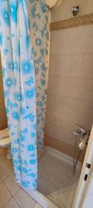 a shower with a blue shower curtain in a bathroom at Panos & Maria studio! in Kalamata