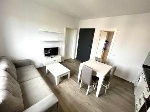 ein Wohnzimmer mit einem Sofa, einem Tisch und Stühlen in der Unterkunft H&A Guest House in Divjaka