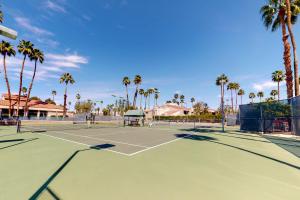 a tennis court with palm trees in the background at Canyon Shores Desert Escape in Cathedral City