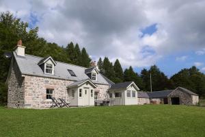 a large stone house with a grass yard at Middleton Farmhouse in Inverness