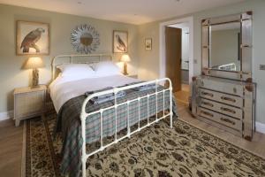 a bedroom with a bed and a dresser and a mirror at Middleton Farmhouse in Inverness