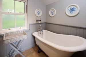 a bathroom with a tub and a sink and a window at Middleton Farmhouse in Inverness +18 photos