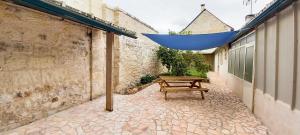 Studio sur chemin de Compostelle في Port-de-Piles: مظلة زرقاء معلقة على فناء مع مقعد