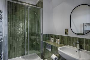a bathroom with a shower and a sink and a mirror at The Railway Hotel Worthing in Worthing