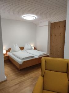 ein Schlafzimmer mit einem Bett und einem Stuhl darin in der Unterkunft Amadee Appartements in Bad Kleinkirchheim