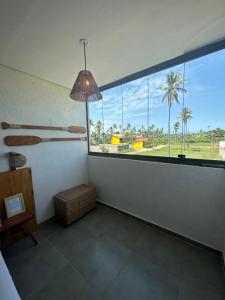 a room with a large window with a view of a field at Casa Natture Patacho in Pôrto de Pedras