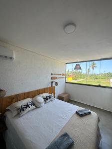 a bedroom with a large bed with a large window at Casa Natture Patacho in Pôrto de Pedras +28 photos