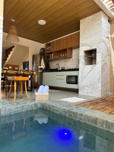 a kitchen and dining room with a swimming pool in a house at Casa Natture Patacho in Pôrto de Pedras