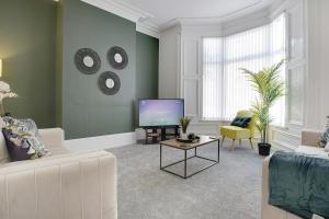 a living room with a couch and a tv at Spacious & Modern Oasis, 4-Bed House, Sleeps 7 in Sunderland