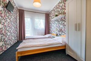 1 dormitorio con 1 cama y papel pintado con motivos florales en Pension u Jezu, en Klášterec nad Ohří
