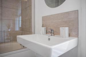 een witte wastafel in een badkamer met een douche bij Spacious & Modern Oasis, 4-Bed House, Sleeps 7 in Sunderland