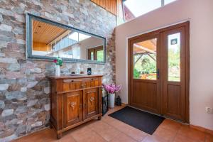 a bathroom with a mirror and a stone wall at Pension u Jezu in Klášterec nad Ohří