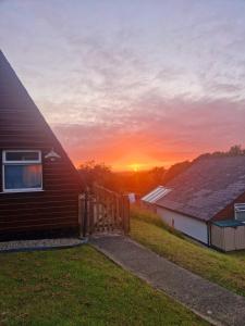 a house with the sunset in the background at 19 the Coombe in Bude