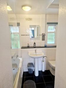 a bathroom with a sink and a tub and a toilet at 19 the Coombe in Bude