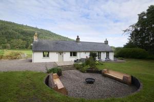 a small white house with a garden in front of it at Upper Dunain in Inverness
