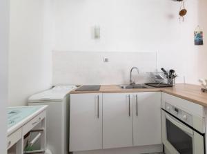 a white kitchen with white cabinets and a sink at chez Elise in Toulon