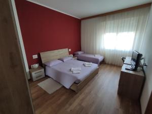 a bedroom with a bed and a television in it at Albergo Al Trieste in Nimis