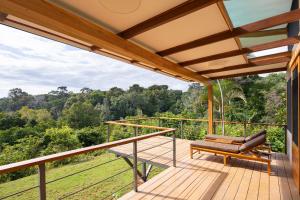 a deck with a bench and a view of the forest at El Remanso Rainforest Lodge in Puerto Jiménez