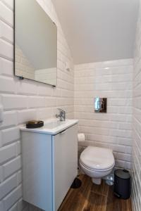 a white bathroom with a toilet and a sink at Privilege Casa dos Capuchinhos, in the heart of Faro in Faro +27 photos