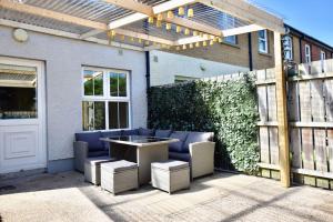 a patio with a table and chairs under a pergola at Portmore Holiday Home in Portrush