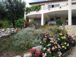 un giardino fiorito di fronte a una casa di Mas des Grives a Bauduen