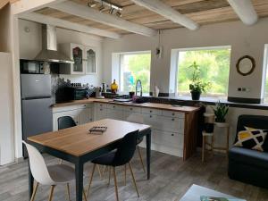a kitchen with a wooden table and a kitchen with a dining room at Le Majol in La Chapelle-sur-Furieuse
