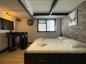 - une chambre avec un lit et un mur en pierre dans l'établissement Copacabana, à Zandvoort