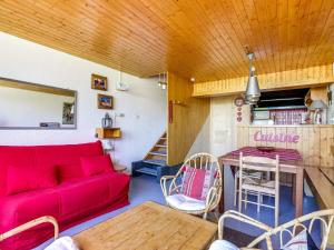 a living room with a red couch and a table at Appartement Les Arcs 1600, 2 pièces, 7 personnes - FR-1-411-504 in Arc 1600