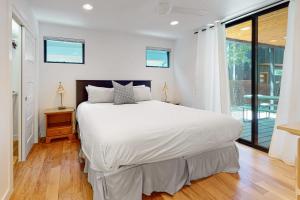 a bedroom with a large white bed and a window at Cozy Austin Hideaway in Austin