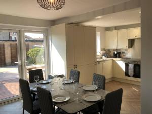 a dining room with a table and chairs and a kitchen at 3 Bed House - Sleeps 6 - Garden - Parking - Wifi in Rye +1 photo