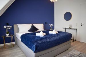 - une chambre bleue dotée d'un grand lit avec des draps bleus dans l'établissement SCHLOSSBERG RESIDENCES - XXL-Design-Apartment mit Schlossblick für bis zu 12 Personen, à Schwetzingen