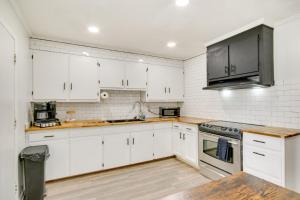 a kitchen with white cabinets and stainless steel appliances at Charming West Columbia Getaway - Near Downtown! in West Columbia