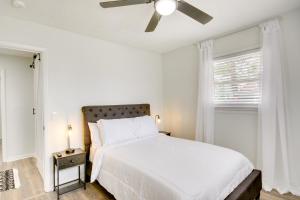Charming West Columbia Getaway - Near Downtown! في ويست كولومبيا: غرفة نوم بيضاء مع سرير ومروحة سقف