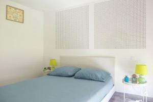 a white bedroom with a bed with blue pillows at Nouveau - Le Privacy - Europa Park in Sand