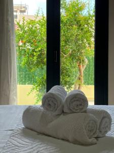 a stack of towels sitting on a bed with a window at Zaros Cottage in Zaros