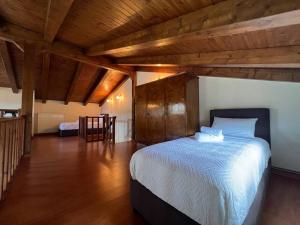Un dormitorio con una cama grande en una habitación con techos de madera. en Zaros Cottage, en Zarós
