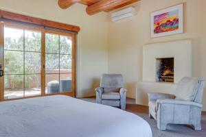 a bedroom with a bed and two chairs and a fireplace at Spacious Santa Fe Vacation Rental about 5 Mi to Town! in Santa Fe