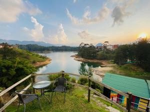a table and chairs sitting on a balcony overlooking a river at La Madriguera in Guatapé